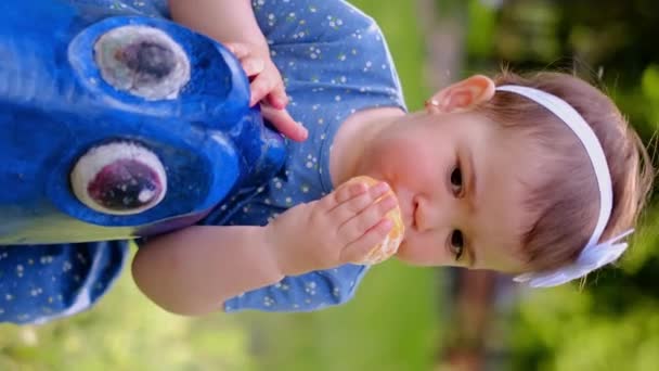 Μικρό Χαριτωμένο Κορίτσι Τρώει Παλσίν Χυμός Πορτοκαλιού Ρέει Κάτω Από — Αρχείο Βίντεο