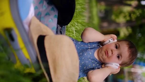 Malé Dítě Žvýkající Poslouchá Hudbu Sluchátkách Tancích Parku Sedí Otevřeném — Stock video