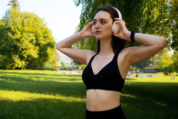 Bir Kadın Ayakta Durup Kulaklıkla Müzik Dinler Yaz Aylarında Parkta — Stok fotoğraf