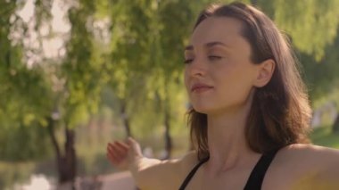 Bahçede yoga yapan genç bir kadın. Mutluluk. Bulanık bir arkaplan. Hippi yaşam tarzı ve rahatlama kavramı. Genç bir kız parkta yoga yapıyor..