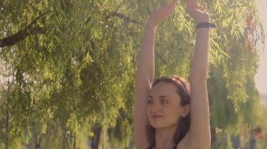 Bahçede yoga yapan genç bir kadın. Mutluluk. Bulanık bir arkaplan. Hippi yaşam tarzı ve rahatlama kavramı. Genç bir kız parkta yoga yapıyor..
