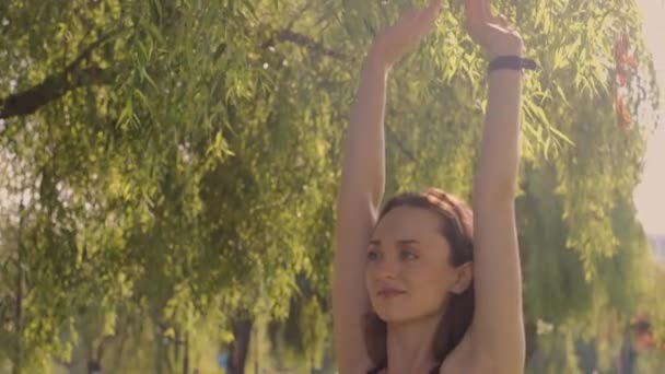 一位年轻女子在花园里练瑜伽 模糊的背景 嬉皮的生活方式和放松的概念 一个小女孩在公园里练瑜伽 — 图库视频影像