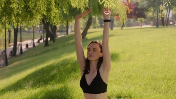 Dziewczyna Pozuje Pozycji Lotosu Zielonej Trawie Parku Otoczonym Naturą Ciesząc — Wideo stockowe