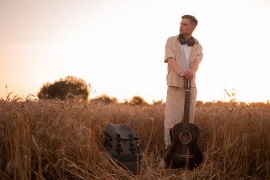 Kampta gitarlı bir adam. Ateşin yanında şarkılar. Kırsaldaki akustik gitarist, müzikal şarkı. Gömlekli, gitarlı seksi bir adam. Hippi modası.