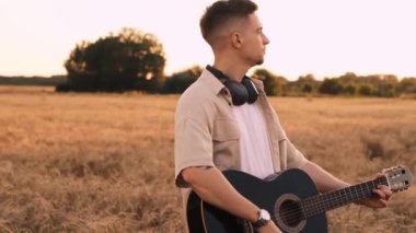 Dışarıda gitar çalan adam, dinlenme tesisinde gezen gezgin, yürüyüş yapan, akustik gitar çalan adam.