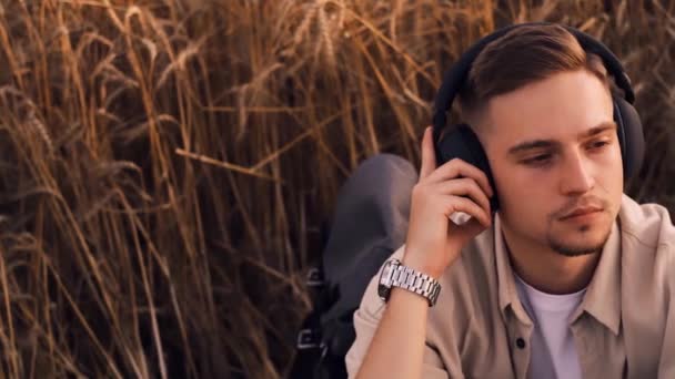 Kulaklık Takan Müzik Dinleyen Çimlerin Üzerinde Uzanan Genç Adam Mutlu — Stok video