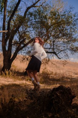 Genç bir kadın bir sonbahar günü dışarıda dinleniyor, ormana gidiyor, ormandaki ahşap bir kütükte oturuyor ve sıcak çay içiyor, doğayla bütünleşiyor, hayatın anlamını arıyor.