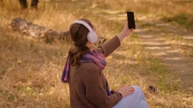 Tablet, sırt çantası ve ormanda gezen kadın macera, hafta sonu veya tatil, dijital teknoloji, telefonda harita, telefonda kendi fotoğrafını çeken MyRealHolida.