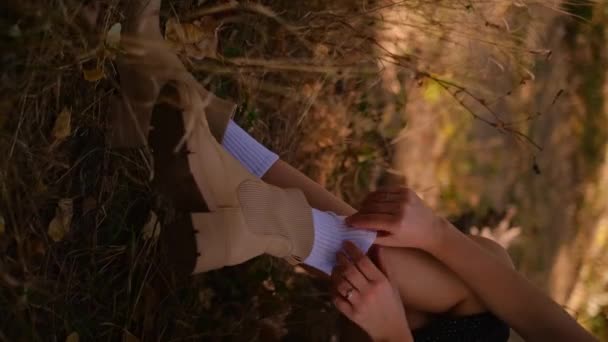 女人穿着袜子坐在树林里 女人的秋靴特写 米色靴子 — 图库视频影像