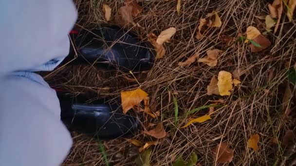 落ち葉の上に立っている男性の足のクローズアップPovトップビュー 秋の公園 黄色い葉の上に立っている男 — ストック動画
