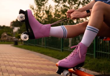 Patenlerle ayakkabı bağlayan artistik patinajcıların elleri yakın plan çekimlerde genç kadın paten kayıyor.