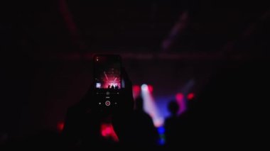 Adamın elleri video kayıtlarını cep telefonuyla kaydediyor. Bir grup hayran canlı bir K-Pop konserini kaydediyor. Birçok erkek çılgın festivallere gider. Eğlence grubu, gece kulübü salonu. Yıldız DJ elini kaldırıyor..