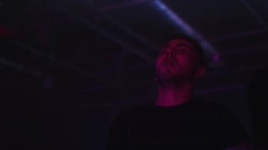 Bir gece kulübünde dans eden kalabalık diskolar. Uluslararası tekno DJ. Gençlik kültürü müzik ve gösterilerle bir gece kulübünde parti veriyor. İnsanlar için kulüp eğlencesi. Neşeli aktif erkek DJ dans ediyor