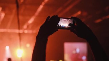 Adamın elleri video kayıtlarını cep telefonuyla kaydediyor. Bir grup hayran canlı bir K-Pop konserini kaydediyor. Birçok erkek çılgın festivallere gider. Eğlence grubu, gece kulübü salonu. Yıldız DJ elini kaldırıyor..