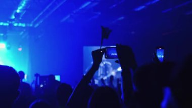 Adamın elleri video kayıtlarını cep telefonuyla kaydediyor. Bir grup hayran canlı bir K-Pop konserini kaydediyor. Birçok erkek çılgın festivallere gider. Eğlence grubu, gece kulübü salonu. Yıldız DJ elini kaldırıyor..