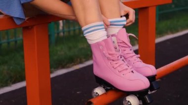 Klasik patenlerle bağcıklarını bağlayan kız, yakın plan eller, yeşil çimenli pembe patenler