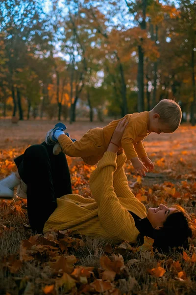 Anne ve çocuk sonbahar parkında oynuyorlar, mutlu aile, anne ve bebek parkta.