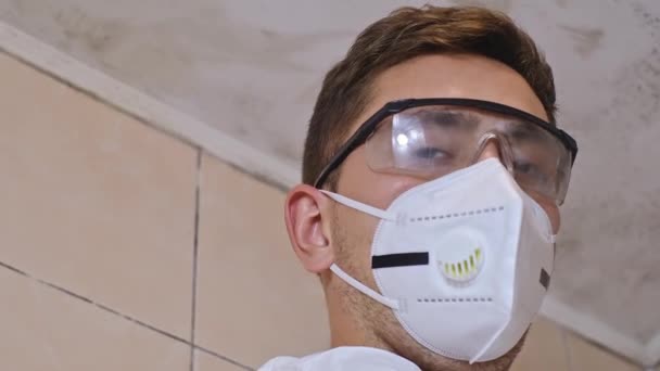 型のクリーニング 金型の浴室および殺すために化学薬品を噴霧する専門の保護スーツの男 — ストック動画