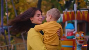 Anne ve oğlu parkın altın renkleriyle çevrili neşeli anları paylaşıyor. Sıcaklık ve aile bağları taşımak için ideal sonbaharın sihrini tecrübe etmek için.