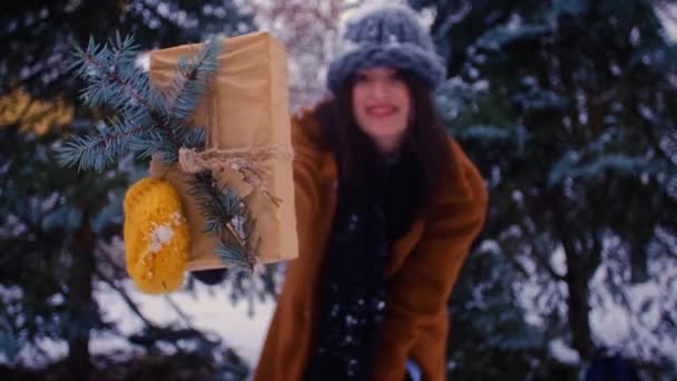 Μια Γυναίκα Κρατάει Ένα Τυλιγμένο Χριστουγεννιάτικο Δώρο Ένα Χειμερινό Δάσος — Αρχείο Βίντεο