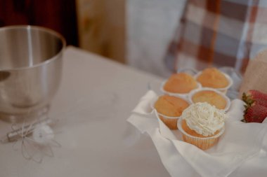 Masanın üzerinde kek var. Pasta fırıncısının sanatını sergiliyorlar. Mutfak masasında bir pasta şefinin aletleri ve malzemeleri var. Mutfak ürünleri için hazır..