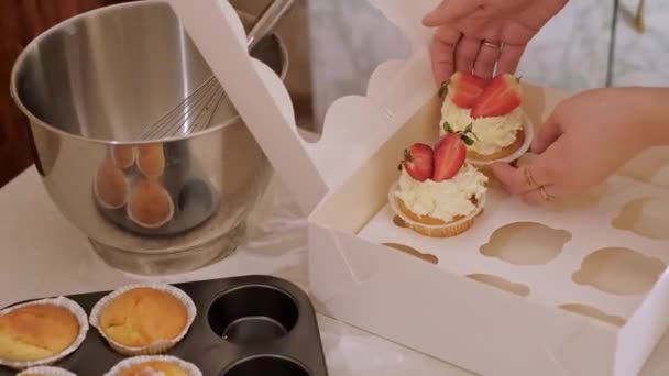 一个女糕点厨师把纸杯蛋糕装进了一个盒子 烘焙家庭 小企业 生态友好型生产 无麸质 促进健康饮食习惯 — 图库视频影像