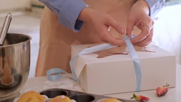一个女糕点厨师把纸杯蛋糕装进了一个盒子 烘焙家庭 小企业 生态友好型生产 无麸质 促进健康饮食习惯 — 图库视频影像