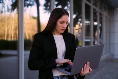 Diz üstü bilgisayarı olan bir iş kadını dışarıda çalışır. Ofis çalışanı, sosyal medya yöneticisi ve serbest çalışan olarak dışarıda çalışmaktan zevk alır..
