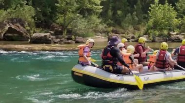 Can yelekli bir grup insan bir dağ nehrinde sallara biniyor. Aktif dinlenme, dağ nehirlerinde rafting, turlar ve dinlenme alanlarına geziler. Sıra dışı turizm.
