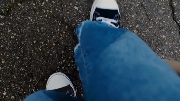 분위기 아스팔트에 다리의 스포티 신발과 세련된 청바지 운동화 — 비디오