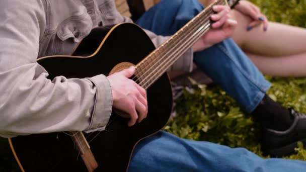 野外キャンプ場でギターを弾く男 アウトドアアクティビティを楽しむ ミュージカル楽器 フェスティバル イベント — ストック動画