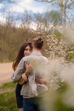 Bir kız, çiçek açan bahçelerin ve çiçeklerin kokusunun ortasında, doğanın inziva ve eğlence yerlerinin tadını çıkararak, ortağını arkadan kucaklıyor. Sevgililer Günü