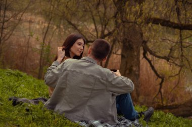 Ormandaki ilk buluşma, göl kenarında kamp yapmak ve parkta çay içmek. Bir erkek, kadının saçlarını nazikçe okşar. Romantik bir bağ ve dostluğu simgeler. Sevgililer Günü