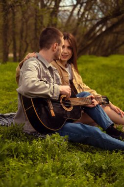 Ormanda piknik yapan genç bir çift. Gitar çalan bir adam, genç aşıklar ve arkadaşlık, ilk randevu, açık havada eğlenen genç turistler. Sevgililer Günü