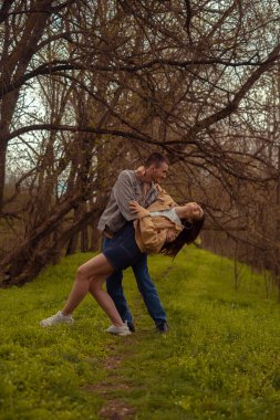 Bir erkek ve bir kız ormanda dans ediyor, romantik bir ilişki ve arkadaşlık, ormanda piknik, Sevgililer Günü