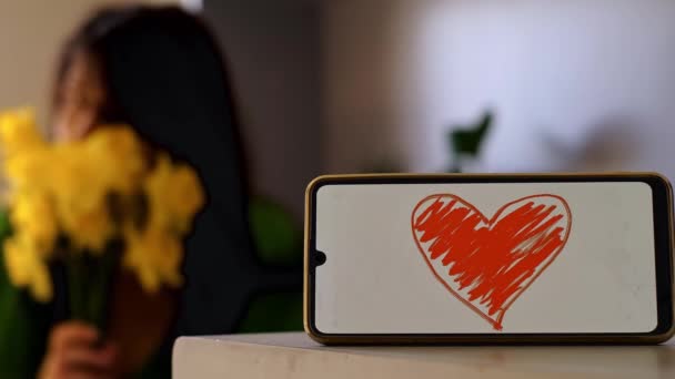 Vordergrund Ein Herzsymbol Auf Einem Telefonbildschirm Hintergrund Ein Mädchen Mit — Stockvideo