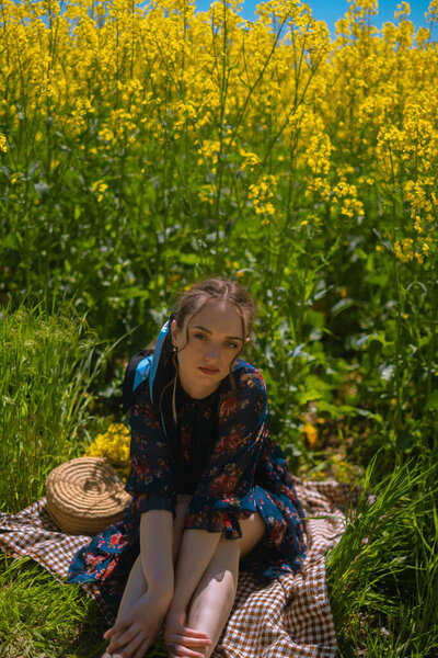 Handmade bag advertisement, showcasing regional crafts passed down through generations, featured in a field picnic with a girl.