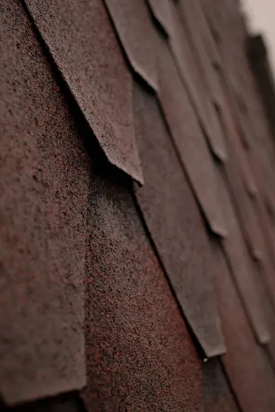 A close-up of red shingle roof, emphasizing waterproofing and leak repair. Highlight your company\'s assurance of reliable home protection from moisture and roof waterproofing.