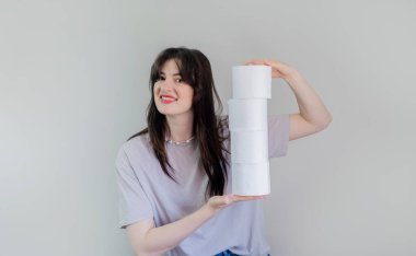 Gri arka planda tuvalet kağıdı ruloları olan bir kadın, okullar, ofisler ve umumi tuvaletler gibi kamusal alanlarda hijyenin önemine dair farkındalığı artırma amaçlı reklam kampanyaları yürütüyor..