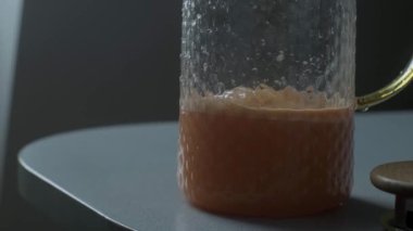 Kadın bardağa taze havuç ve elma suyu dolduruyor. Sağlıklı bir yaşam için vitaminli içecek..