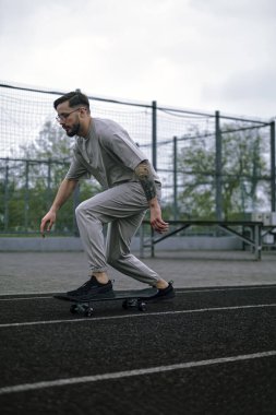 Lastiklenmiş yüzeyde kaykay yapan genç çocuk, kaykay tekniği ve numaralar gösteriyor..