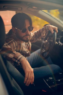 Direksiyondaki bir adamın portresi, yeni başlayanlara yol kurallarını ve güvenli sürüş uygulamalarını öğreten bir sürücü eğitmeni..