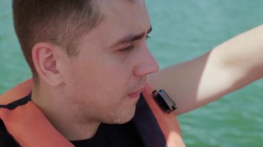 Çocuk ve yetişkinlere yüzme ve su güvenliğini öğretmeye adanmış can yeleği giymiş bir gencin portresi..