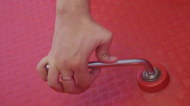 Erkek elinin katamaran tekerleğini döndürüp suyun kontrolü için farklı yönlere çevirdiği yakın plan..