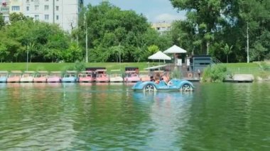 Aile denizde geziyor, parkta bir gölde birlikte pedal çeviriyor, eğlence dolu bir günün tadını çıkarıyor..