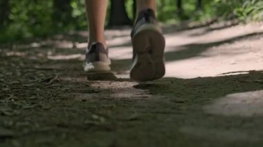 Parkta sabah koşusu, kameradan kaçan bir adamın spor ayakkabılarına yakın çekim, aktif bir yaşam tarzını kucaklamak..