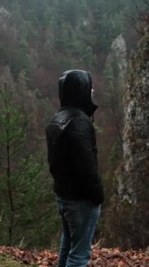 Turist dağlarda meditasyon yapar, manzaraya bakar, sabah sisi ve bulutuyla, yağmurlu havayla.