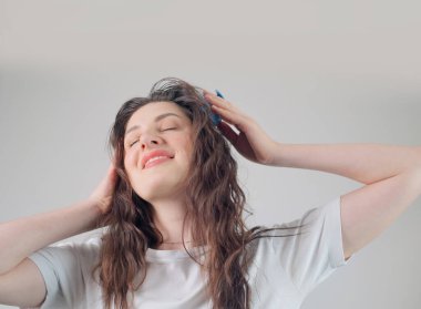 Beyaz kadın kafa masajından hoşlanıyor, bu da kan dolaşımını arttırıyor, saç foliküllerini besliyor ve saç uzamasını destekliyor..