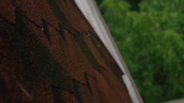 Şiddetli yağmur altında çatıya yakın çekim yapmak, doğal afetlere ve hava hasarına karşı koruma sağlayan sigorta hizmetlerini ön plana çıkarmak.