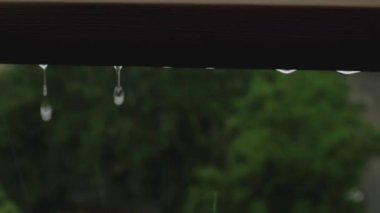 Pencereden süzülen büyük yağmur damlacıkları, evin içinden yaz yağmuru izleniyor..